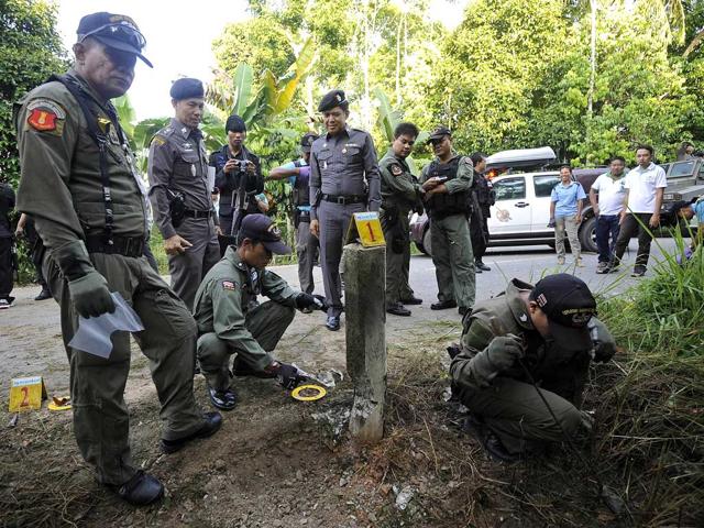 Members of a Thai bomb squad unit inspect a damage roadside caused from a bomb attack by separatist militants in Narathiwat province. AFP/Madaree Tohlala