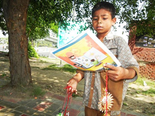 A child goes through a textbook printed in Hindustan Times and gifted to him by a reader. Hindustan Times is distributing over 10 lakh textbooks with its newspapers