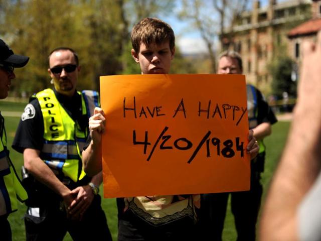 Colorado University senior Gabriel Kuettel holds up a sign at the Norlin Quad which was closed to crackdown on pro-marijuana protesters at the school in Boulder, Colo. A block-long line of protesters marched onto the University of Colorado, testing the school's determination to push the annual April 20 marijuana celebration off campus. (AP Photo/The Denver Post, Joe Amon)