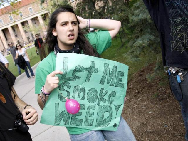 A woman holds a sign at a pro-marijuana rally at the University of Colorado in Boulder. The University of Colorado clamped down on a huge annual marijuana fest by restricting access to the school and a field where the "smoke-in" is traditionally held, and three protesters were arrested ahead of the event. The event was held on April 20, a date corresponding with a numerical 4/20 code widely known within the cannabis subculture as a symbol for all things marijuana. REUTERS/Rick Wilking