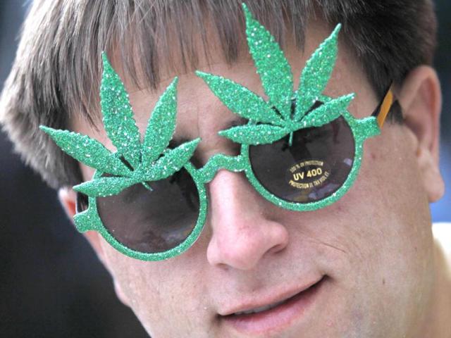 Brandon Dahl wears novelty sunglasses adorned with artificial marijuana leaves as he sells them across the street from a pro-marijuana rally at the University of Colorado in Boulder, Colorado. The University of Colorado clamped down on a huge annual marijuana fest on Friday by restricting access to the school and a field where the "smoke-in" is traditionally held, and three protesters were arrested ahead of the event. The event was held on April 20, a date corresponding with a numerical 4/20 code widely known within the cannabis subculture as a symbol for all things marijuana. REUTERS/Rick Wilking