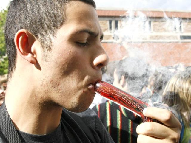 A man smokes marijuana in a pipe at a pro-marijuana rally at the University of Colorado in Boulder, Colorado. The University of Colorado clamped down on a huge annual marijuana fest on Friday by restricting access to the school and a field where the "smoke-in" is traditionally held, and three protesters were arrested ahead of the event. The event was held on April 20, a date and time corresponding with a numerical 4/20 code widely known within the cannabis subculture as a symbol for all things marijuana. REUTERS/Rick Wilking