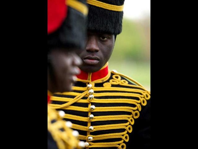 A member of the gun team from the Kings Troop of the Royal artillery looks on as she awaits the firing of a 41 gun salute in London's Hyde Park in honour of her Royal Highness Queen Elizabeth II's 86th birthday in central London. AFP Photo / Leon Neal