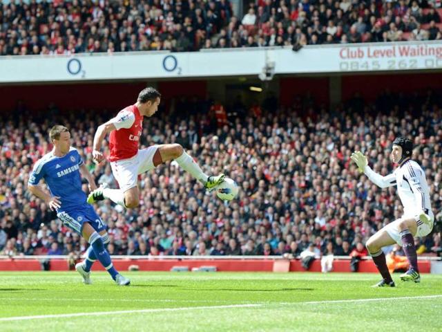 Arsenal's Dutch striker Robin Van Persie (2nd L) shoots under pressure from Chelsea's English defender John Terry (L), as Chelsea's Czech goalkeeper Petr Cech watches (R) during the English Premier League football match between Arsenal and Chelsea at The Emirates Stadium in north London. (AFP Photo/Adrian Dennis)