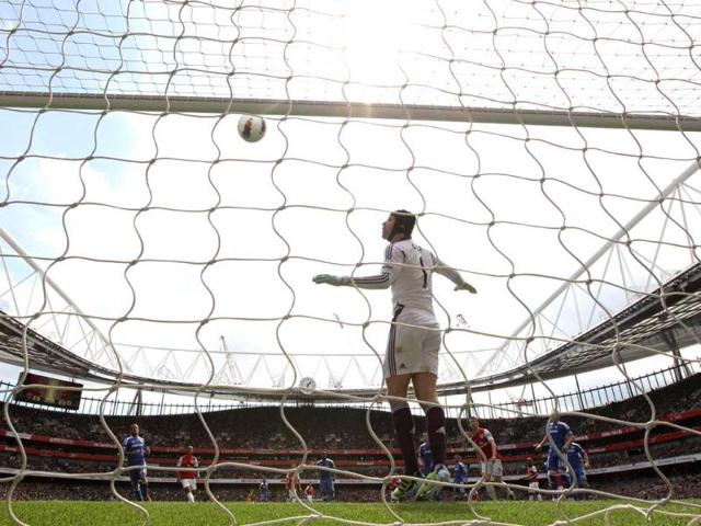 Arsenal's Czech goalkeeper Petr Cech watches Arsenal's French defender Laurent Koscielny's attempt hit the bar during the English Premier League football match between Arsenal and Chelsea at The Emirates Stadium in north London, England. (AFP Photo/Adrian Dennis)