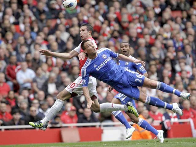 Arsenal's Robin van Persie, left, fights for the ball with Chelsea's John Terry during their English Premier League soccer match at the Emirates stadium, London. (AP Photo/Sang Tan)