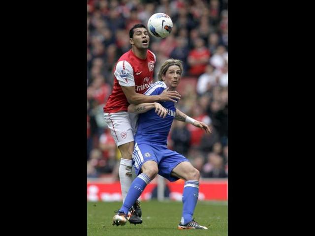 Arsenal's Andre Santos, left, fights for the ball with Chelsea's Fernando Torres during their English Premier League soccer match at the Emirates stadium, London. (AP Photo/Sang Tan)