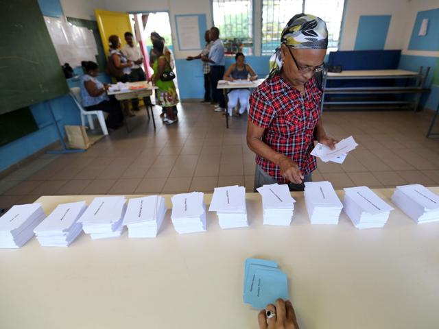 A woman picks up ballots prior voting at a polling station in La Possession in the French Indian ocean island of La Réunion, for the first-round poll of French 2012 presidential election. AFP/Richard Bouhet