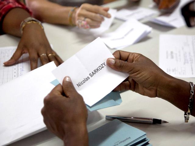 A woman holds a ballot of France's incumbent President and right-wing ruling party Union for a Popular Movement (UMP) candidate for the French 2012 presidential election Nicolas Sarkozy during the counting at a polling station after the residents of Cayenne, French Guiana, voted for the 2012 French presidential election. AFP/Jerome Valette