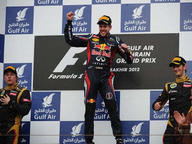 Red Bull Racing's German driver Sebastian Vettel and Lotus F1 Team's French driver Romain Grosjean celebrate on the podium at the Bahrain International circuit in Manama after the Bahrain Formula One Grand Prix. (AFP Photo/Dimitar Dilkoff)