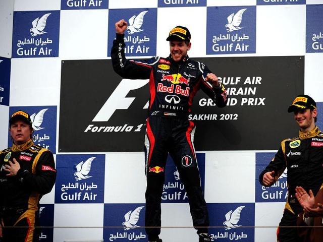 (L to R) Lotus F1 Team's Finnish driver Kimi Raikkonen, Red Bull Racing's German driver Sebastian Vettel and Lotus F1 Team's French driver Romain Grosjean celebrate on the podium at the Bahrain International circuit in Manama after the Bahrain Formula One Grand Prix. (AFP Photo/Dimitar Dilkoff)