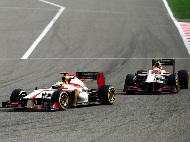 (L to R) HRT F1 Team's Spanish driver Pedro Martinez de la Rosa and HRT F1 Team's Indian driver Narain Karthikeyan compete at the Bahrain international circuit in Manama during the Gulf kingdom's Formula One Grand Prix. (AFP Photo/Tom Gandolfini)