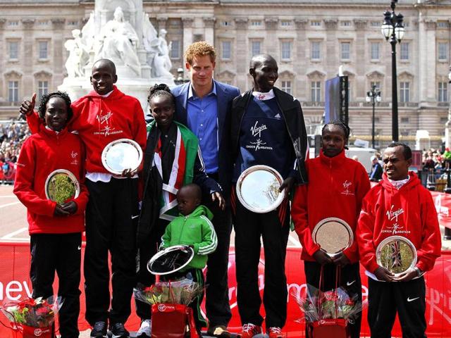 Britain's Prince Harry, center, poses with men and women first, second and third place finishers during the trophy presentation in the London Marathon. From left are, women 2nd placed Kenya's Edna Kiplagat, men 2nd placed Kenya's Martin Lel, women's winner Kenya's Mary Keitany, Prince Harry, men's winner Kenya's Wilson Kipsang, women 3rd placed Kenya's Priscah Jeptoo and men 3rd placed Ethiopia's Tsegaye Kebede. (AP Photo)
