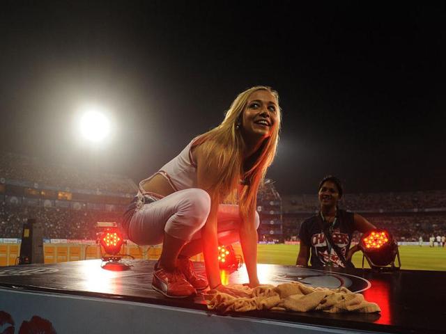 A Deccan Chargers cheerleader clears water off their platform as the IPL Twenty20 cricket match between Deccan Chargers and Kolkata Knight Riders is delayed due to rain in Cuttack. (AFP Photo/Dibyangshu Sarkar)
