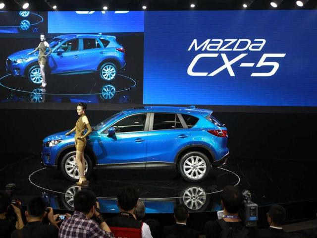 A model poses with Mazda's newly launched SUV CX-5 at the Beijing International Auto Exhibition in China. AP Photo/Vincent Thian
