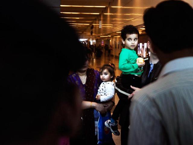 Abhigyan Bhattacharya, 3, center right and his sister Aishwarya arrive at the airport in New Delhi. AP/Manish Swarup