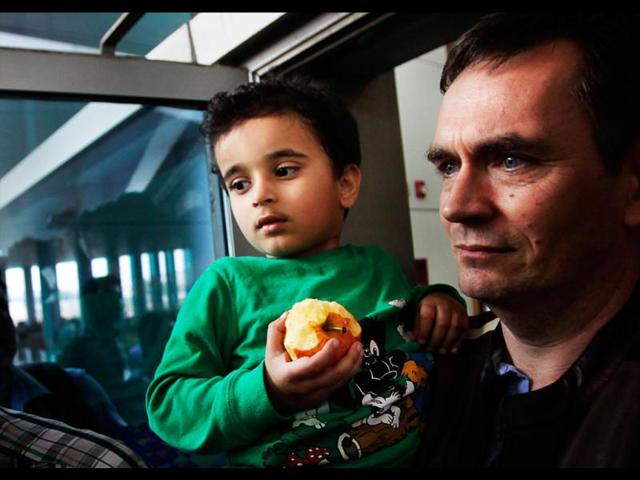 Abhigyan Bhattacharya, 3, is carried by his Norwegian foster father as they arrive at the airport in New Delhi. AP/Manish Swarup