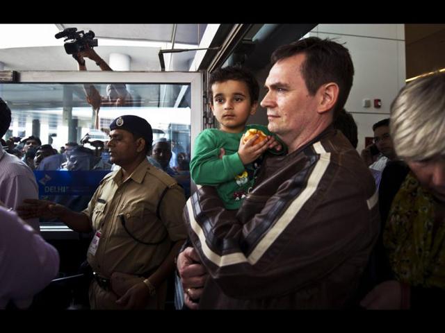 Three year old Abhigyan Bhattacharya is held by his Norwegian foster father upon their arrival at IGI airport in New Delhi. AFP/Prakash Singh