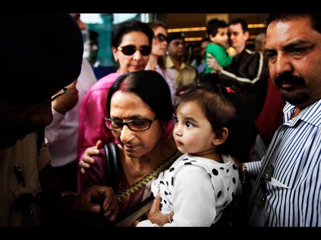 Aishwarya Bhattacharya, 1, is carried by her grandmother as she arrives at the airport in New Delhi. Aishwarya and her brother, caught in a custody row in Norway, returned home to India after a court ruled they be handed over to their uncle. AP/Manish Swarup