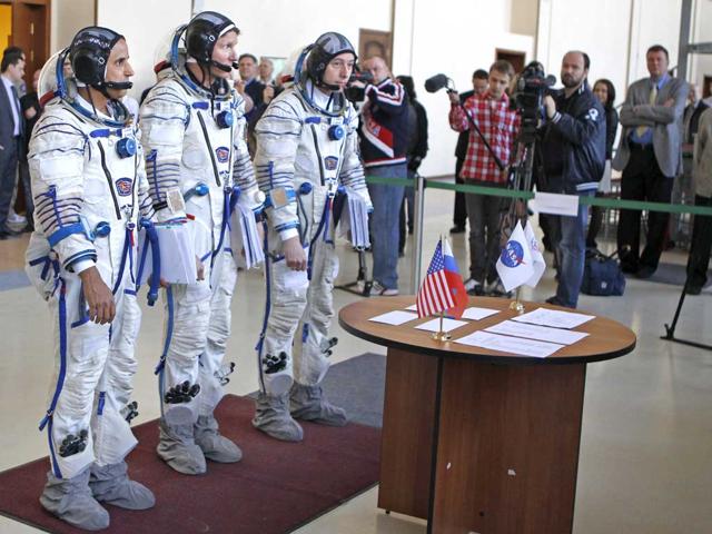 Members of the next expedition to the International Space Station, US astronaut Joseph Acaba, left, and Russian cosmonauts Genady Padalka, center, and Sergey Revin, right, stand together before their final preflight practical examination in a mock-up of a Soyuz TMA space craft at Russian Space Training Center in Star City outside Moscow, Russia. (AP Photo/Mikhail Metzel)