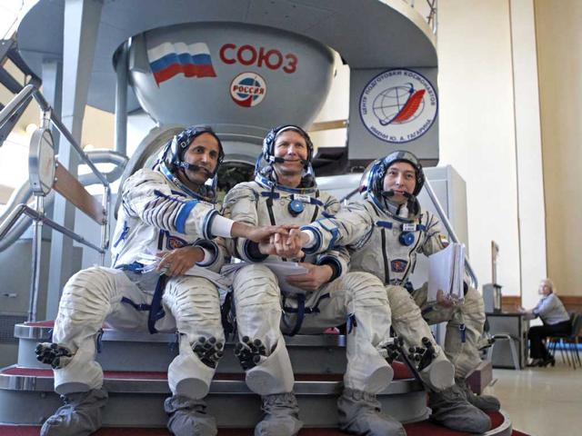 Members of the next expedition to the International Space Station, US astronaut Joseph Acaba, left, and Russian cosmonauts Genady Padalka, center, and Sergey Revin, right, shake hands before their final preflight practical examination in Star City outside Moscow, Russia. (AP Photo/Mikhail Metzel)