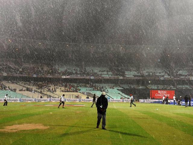 Groundsmen cover the pitch as the IPL Twenty20 cricket match between Deccan Chargers and Kolkata Knight Riders is delayed due to rain at The Eden Gardens in Kolkata. (AFP Photo/Dibyangshu Sarkar)