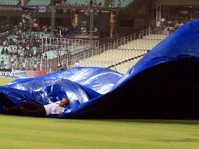 A television commentator slips while groundsmen rush to cover the Eden Gardens pitch in Kolkata. (PTI PhotoSwapan Mahapatra)