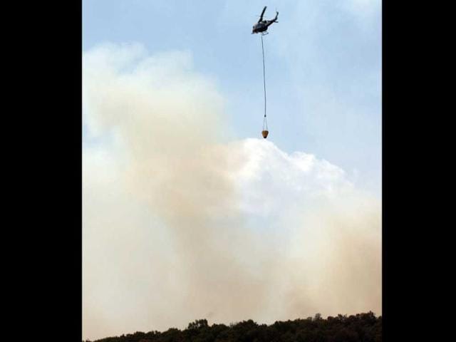 A helicopter drops water over a massive fire raging in "La Primavera" forest in Guadalajara, Mexico. More than 700 firefighters were sent to the site where the fire has been burning uncontrolled for four days now and has consumed over 5000 hectares so far. (AFP Photo)
