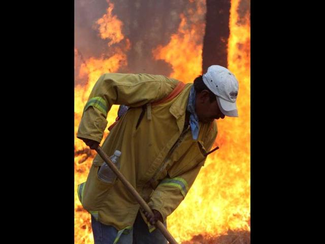 A fireman fights a massive fire raging in "La Primavera" forest in Guadalajara, Mexico. More than 700 firefighters were sent to the site where the fire has been burning uncontrolled for four days now and has consumed over 5000 hectares so far. (AFP Photo)