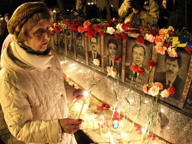 A woman lights candles at a memorial dedicated to firefighters and workers who died after the Chernobyl nuclear disaster in the city of Slavutych. Reuters/Gleb Garanich