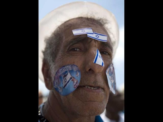 An Israeli man with stickers of the Israeli flag on his face during Israel's 64th Independence Day anniversary celebrations in Tel Aviv, Israel. AP Photo/Ariel Schali