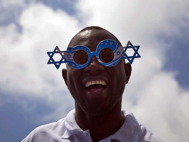 An African migrant worker cheers during Israel's 64th Independence Day anniversary celebrations in Tel Aviv, Israel, Thursday, April 26, 2012. AP Photo/Ariel Schalit