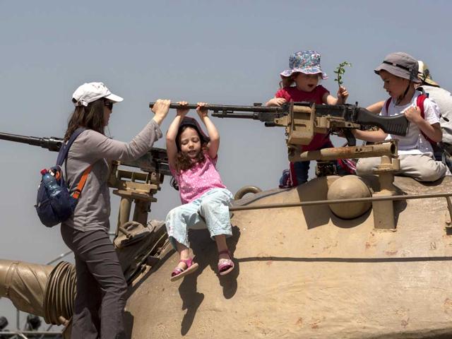 Israeli children play on top of an old military tank during a display by the army at the Armored Corps Museum as part of Independence Day celebrations in Latrun, near Jerusalem. Israel is celebrating its annual Independence Day, marking 64 years since the founding of the state in 1948. AP Photo/Sebastian Scheiner