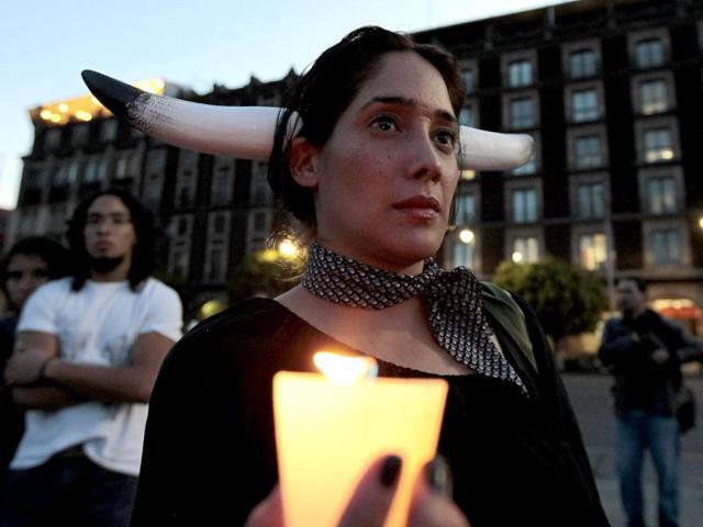 An activist from the animal rights group AnimaNaturalis holds a candle as she takes part a demonstration against bullfights, at the main Zocalo square in Mexico City. Reuters/Henry Romero