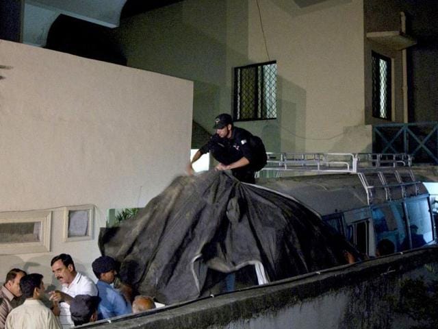 Policemen cover the vehicle carrying the family members of Osama bin Laden with cloth to avoid the media before they leave for the airport in Islamabad. Reuters