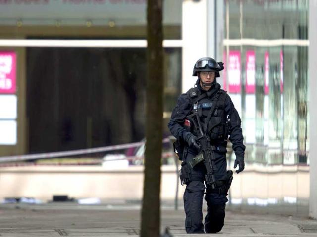 An armed police officer gets ready to take part in an operation to arrest a man reportedly armed with gas canisters at a vehicle licence office in London. AP Photo/Alastair Grant