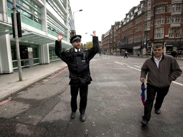 A police officer gestures to members of the public to move away from the scene where according to reports an armed man was causing a disturbance in an office building in central London. AFP Photo/Ben Stansall