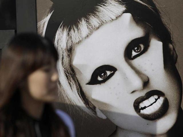 A woman walks past near the picture of US pop diva Lady Gaga before her concert in Seoul, South Korea. AP/Lee Jin-man