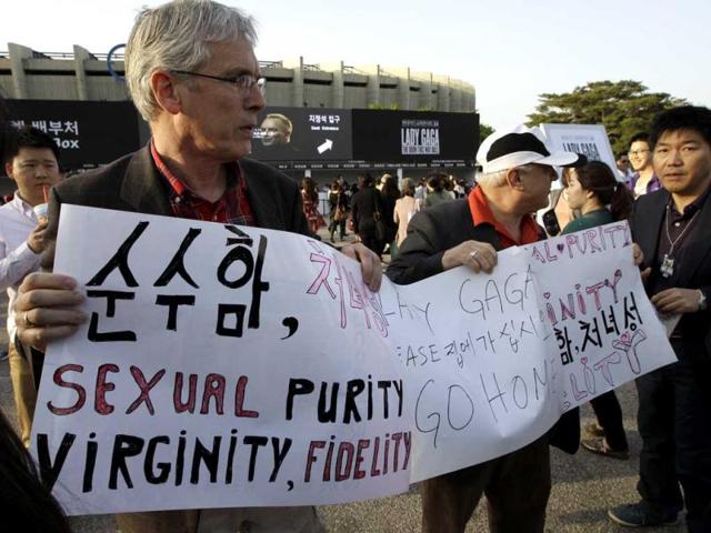 Two missionaries, Jong from the Netherlands(L) and Luciano Fernori from Italy hold signs as they call for the cancellation of a concert of US pop star Lady Gaga just outside the venue in Seoul. AP/Lee Jin-man