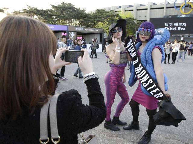 US pop diva Lady Gaga's fans pose for souvenir photos as they wait for Gaga's concert in front of the venue in Seoul. AP/Lee Jin-man