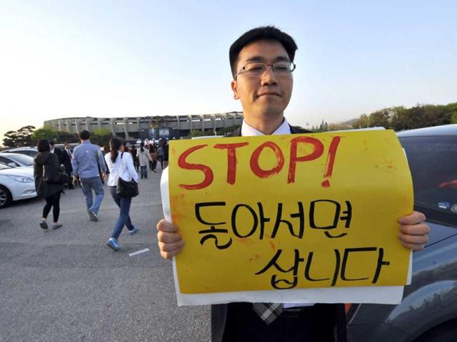 A protestor holds a placard against Lady Gaga ahead of her concert outside Seoul's Olympic Stadium. AFP/Jung Yeon-je
