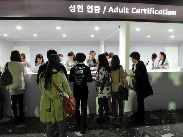 South Koreans present proof of age documents at an adult certification kiosk before attending a concert by US pop singer Lady Gaga outside Seoul's Olympic Stadium. Tens of thousands flocked to the opening show of Lady Gaga's global tour, amid colourful scenes as female and male fans donned outrageous outfits in honour of the US pop diva. AFP/Kim Jae-Hwan