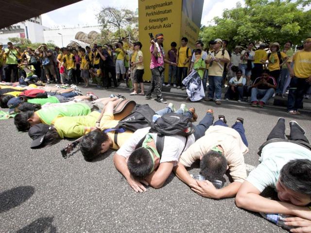 Protesters lie down on a major intersection in the central business district in Kuala Lumpur, Malaysia. AP/Mark Baker