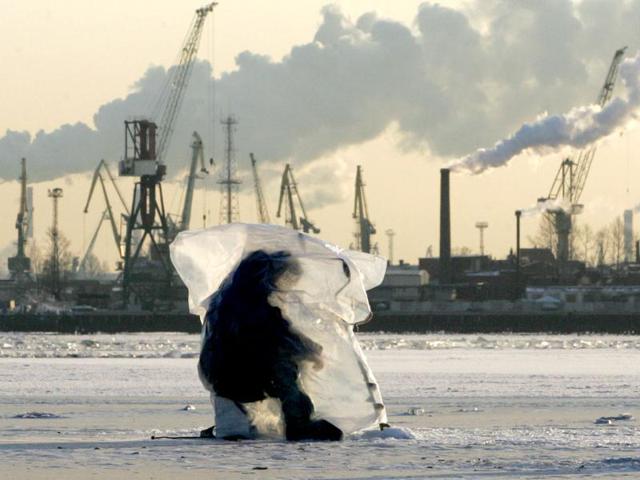 A man takes cover under a plastic foil to protect himself from severe frost while fishing in the Gulf of Finland at St Petersburg's seaport. Reuters/Alexander Demianchuk