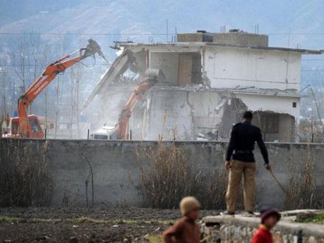 In this file photo, Pakistani policemen stand guard as security personnel conduct demolition works on the compound where al Qaeda chief Osama bin Laden was killed last year in the northwestern town of Abbottabad.