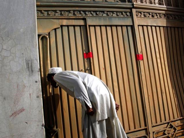 A resident tries to look into the compound where al Qaeda leader Osama bin Laden was reported to have been killed in Abbottabad. (Reuters)