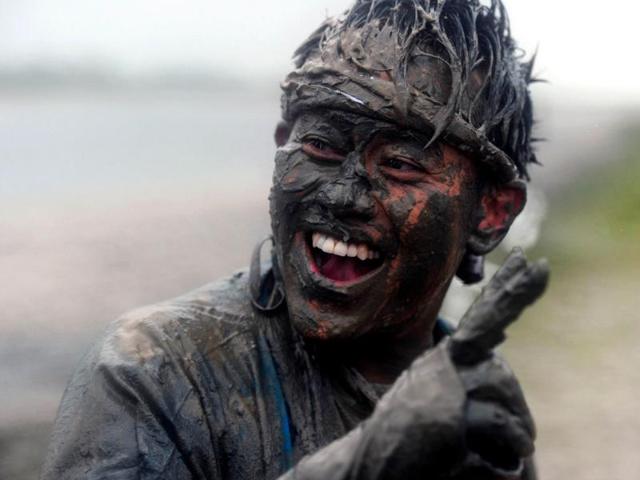 A competitor laughs after taking part in the Maldon Mud Race in Maldon, Essex. AFP/Carl Court