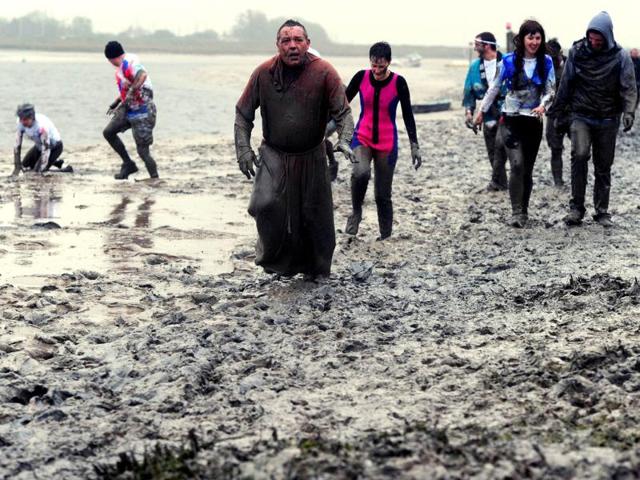 Competitors take part in the Maldon Mud Race in Maldon, Essex. AFP/Carl Court