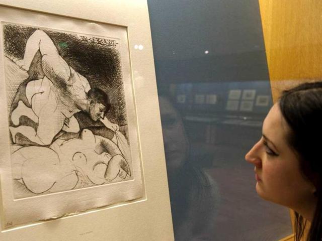 A person looks at a drypoint entitled "Man uncovering a woman (1931)" by spanish artist Pablo Picasso at the British Museum in central London. A set of 100 prints and etchings by the Spanish painter went on display in London. AFP Photo / Miguel Medina