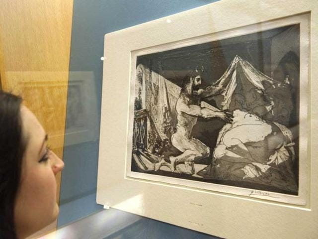 A woman looks at a sugar aquatint, scraper and buring engraving entitled "Faun uncovering a sleeping woman (1936)" by spanish artist Pablo Picasso at the British Museum in central London. A set of 100 prints and etchings by the Spanish painter went on display in London. AFP Photo / Miguel Medina